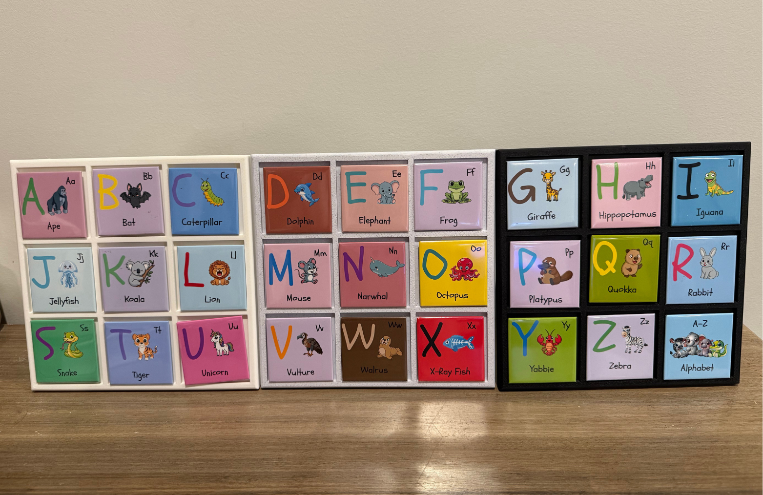 Alphabet flashcards with illustrations on a wooden surface